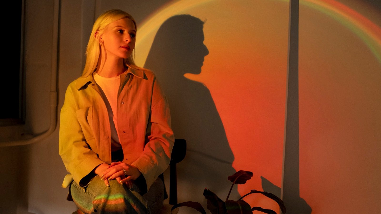 A person seated against a warm, colour-washed wall — reflecting on change